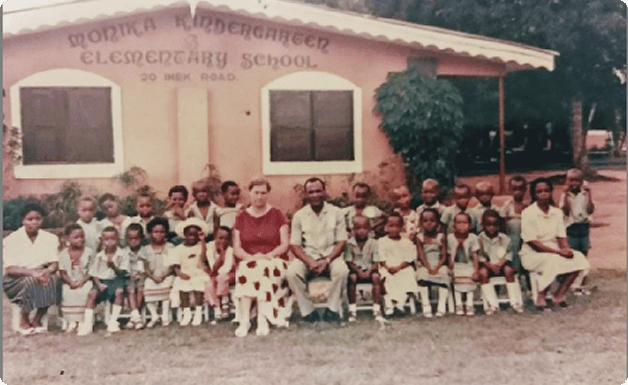 Historisches Foto des ursprünglichen Monika Kindergartens und der Grundschule mit Schülern und Mitarbeitern